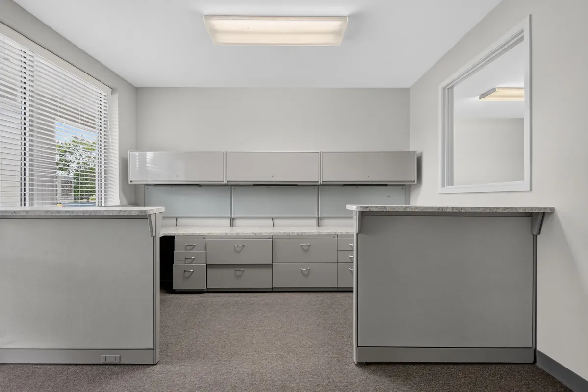 Receptionist assisting client in executive office suite, reflecting professional environment and leasing options available
